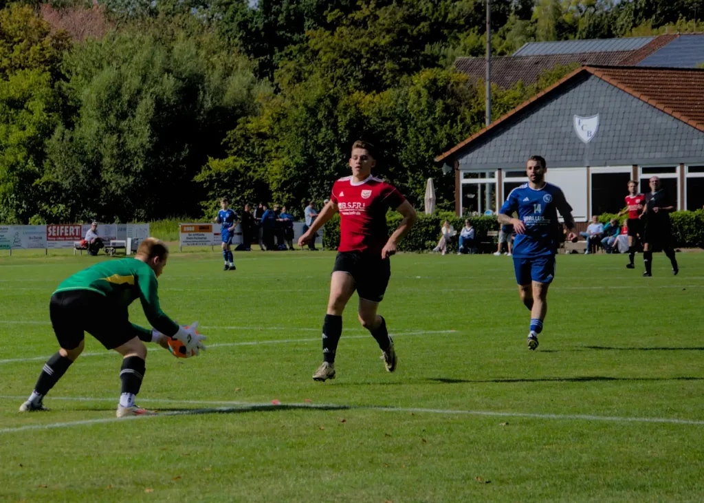 Sportfotografie Region Hannover - Torwart FC Bennigsen fängt den Ball vor dem Weetzener Spieler